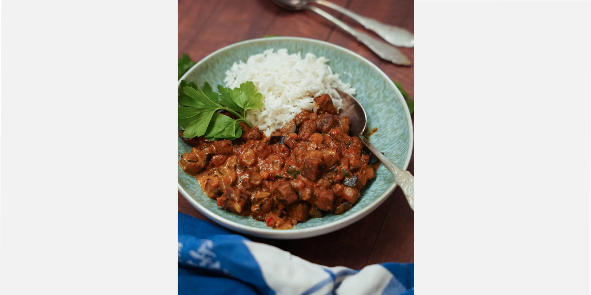 Veganes Tikka Masala im Teller, mit Reis und Koriander angerichtet, Hero