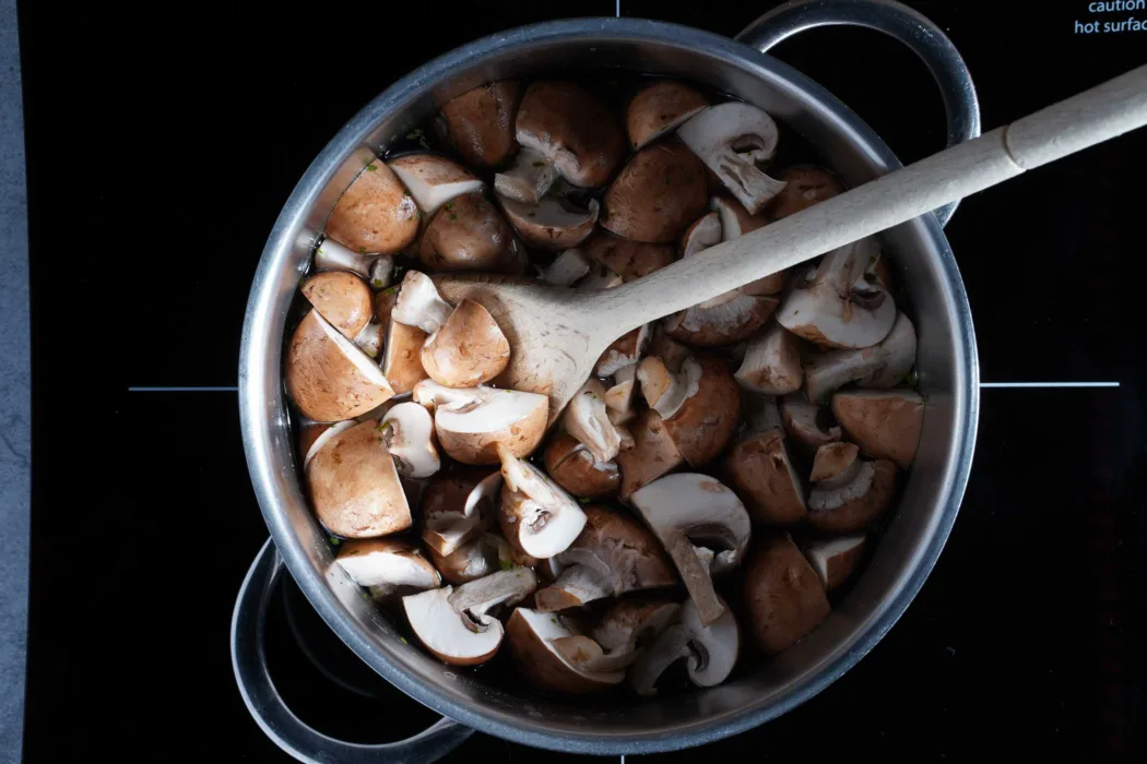 Mushrooms in vegetable broth in the pot