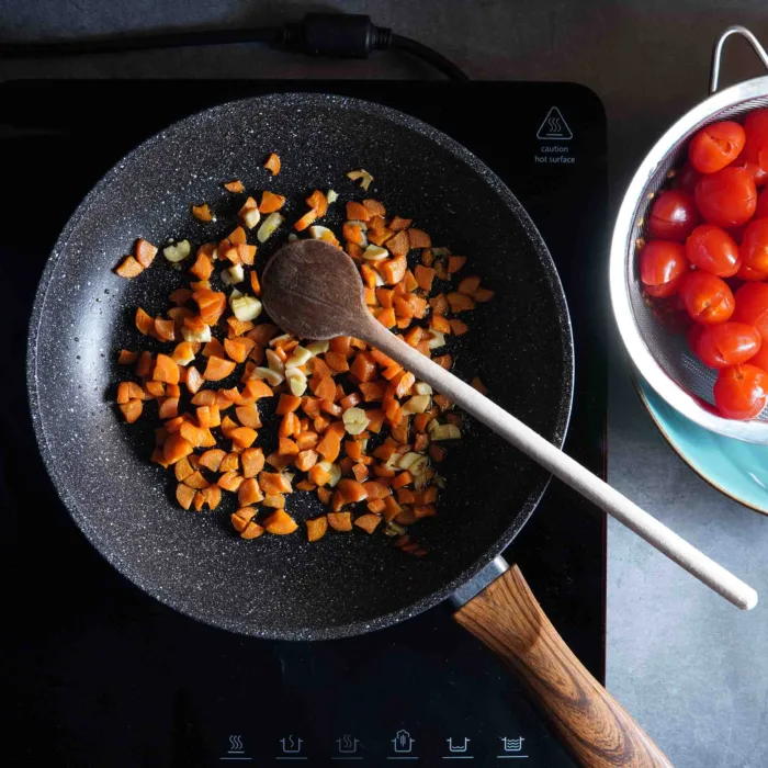 Vegan spaghetti pomodoro, step 2: frying onions and carrots in a pan.