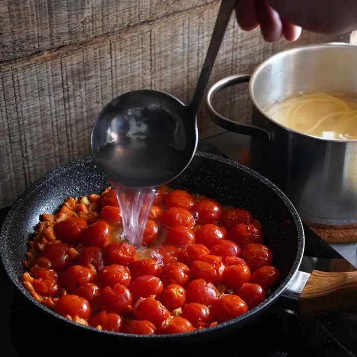 Vegan spaghetti pomodoro, step 3: simmering the tomatoes and deglazing with pasta water.