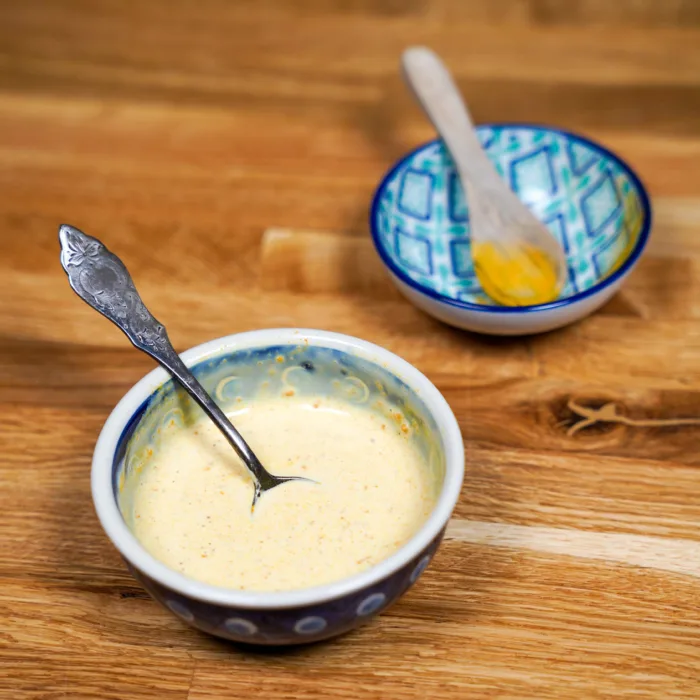 Vegan Easter braid, step 6, soy cream and turmeric are mixed to brush the Easter braid.