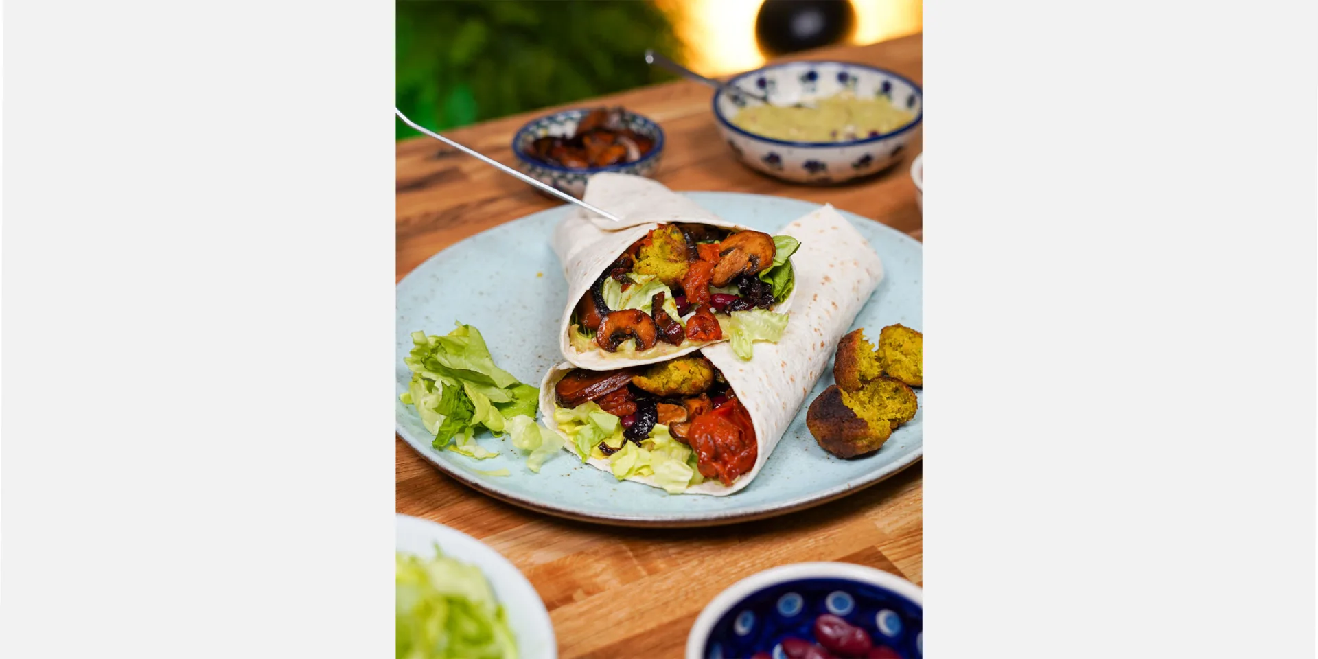 Wraps vegan auf einem Teller angerichtet, darum Dips wie Guacamole und Relish gestellt, Hero