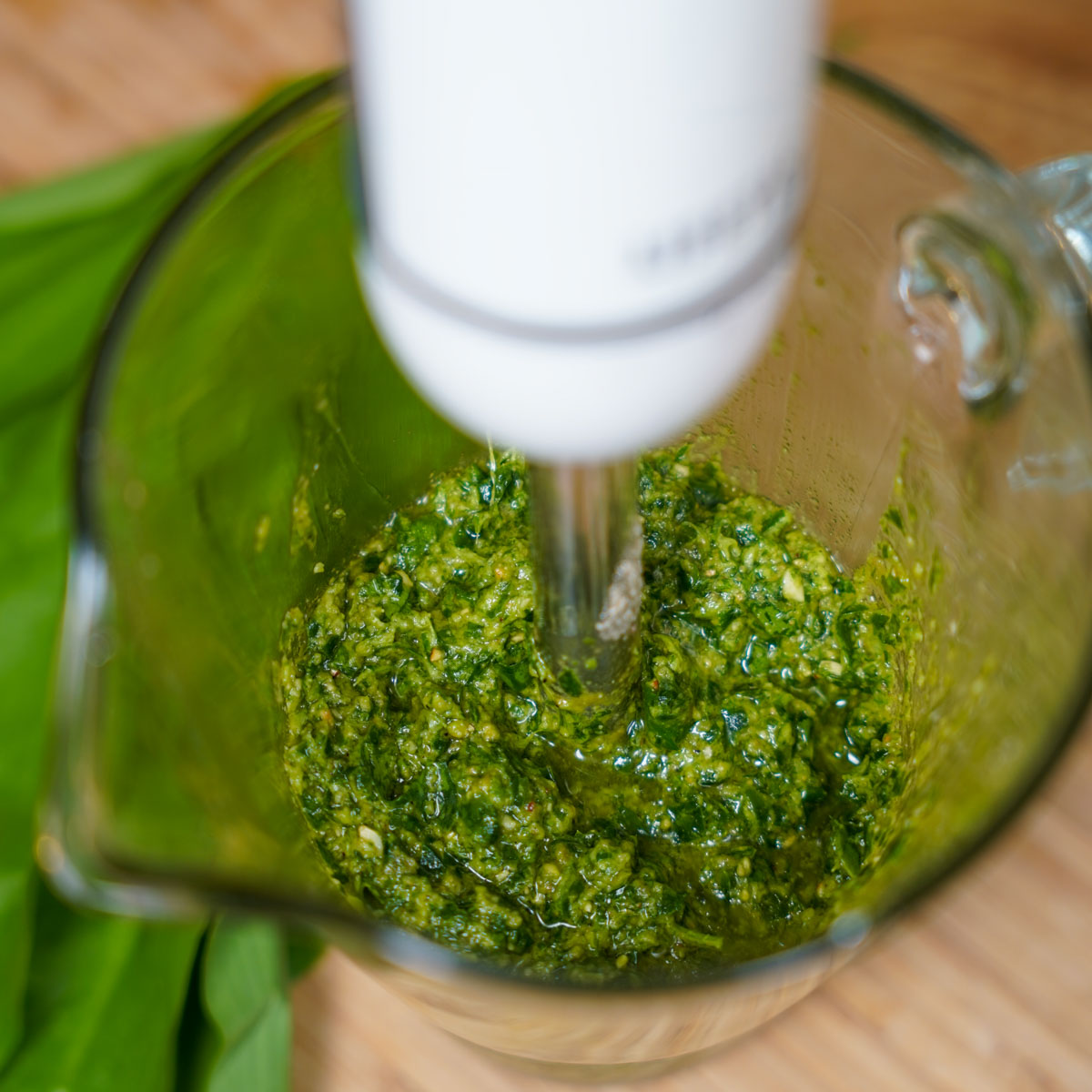 Zutaten in einem hohen Gefäß werden mit einem Pürierstab kleingemixt