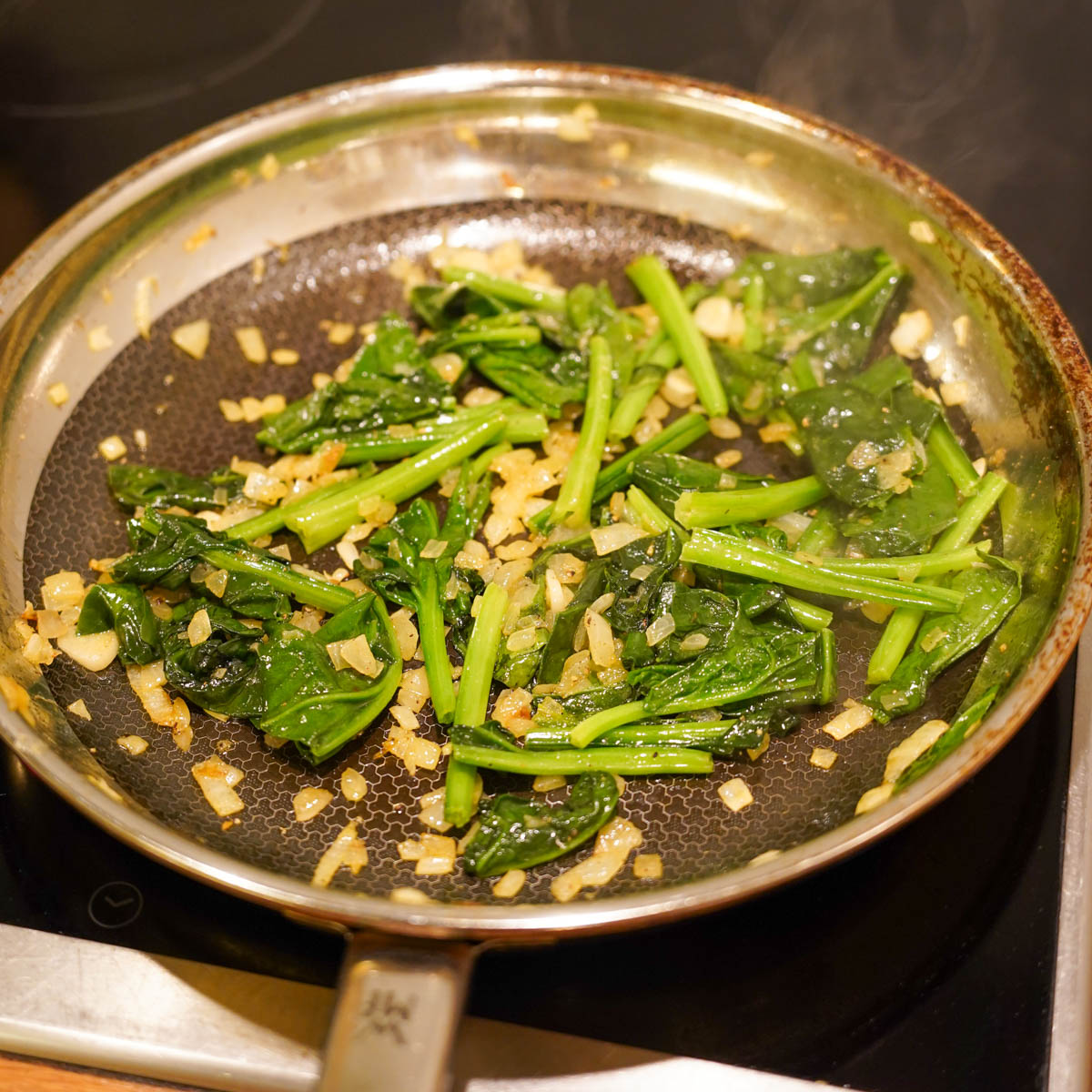 Spinat wird in der Pfanne angebraten