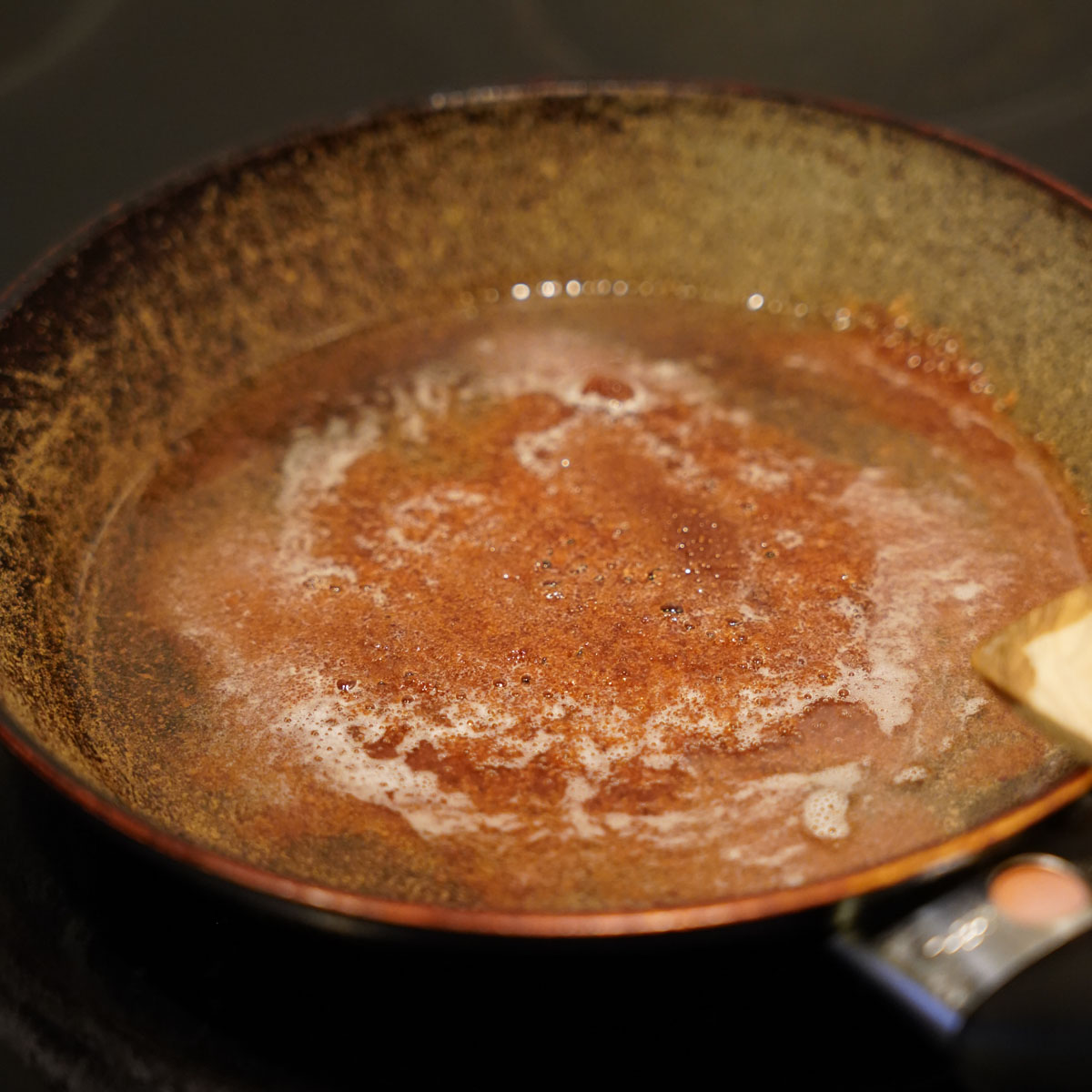 Kokosöl, Ahornsirup und Zucker wird in einer Pfanne flüssig