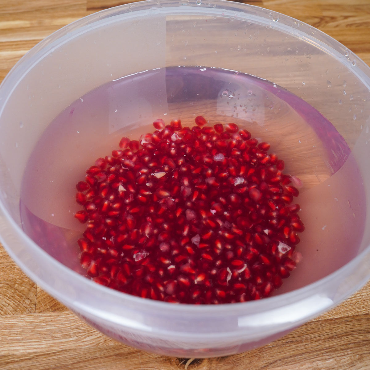 griessbrei mit granatapfel vegan 03 step 1c Granatapfelkerne vereinzelt in einer Schüssel mit Wasser