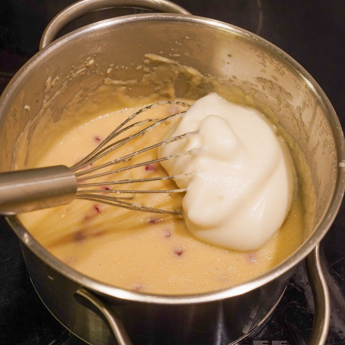 Aquafaba wird unter den veganen Grießbrei gehoben