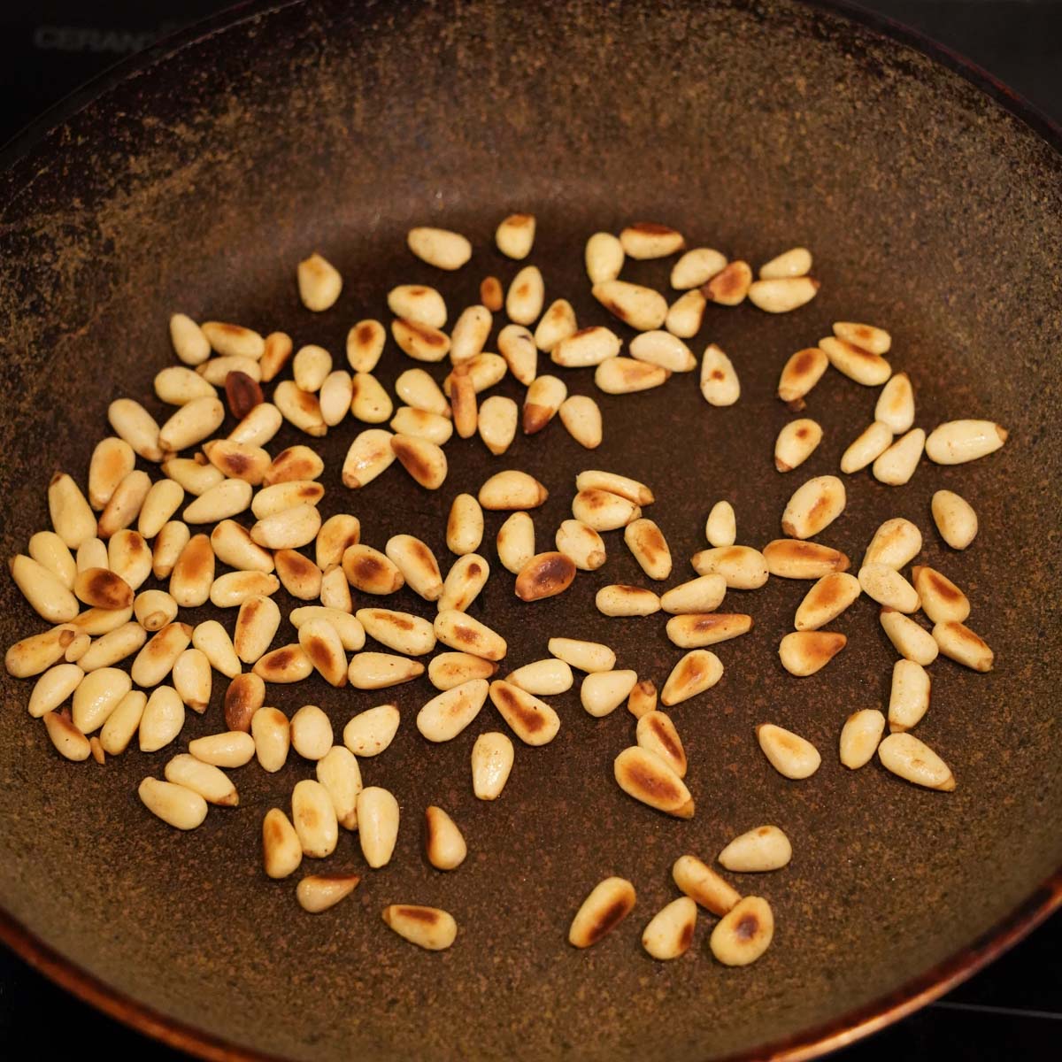 Pinienkerne in einer Pfanne anrösten