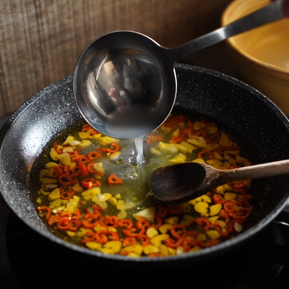 Spaghettiwasser wird in die Pfanne gegeben, damit die Sauce cremig wird. Spaghettiwasser wird in die Pfanne gegeben, damit die Sauce cremig wird.