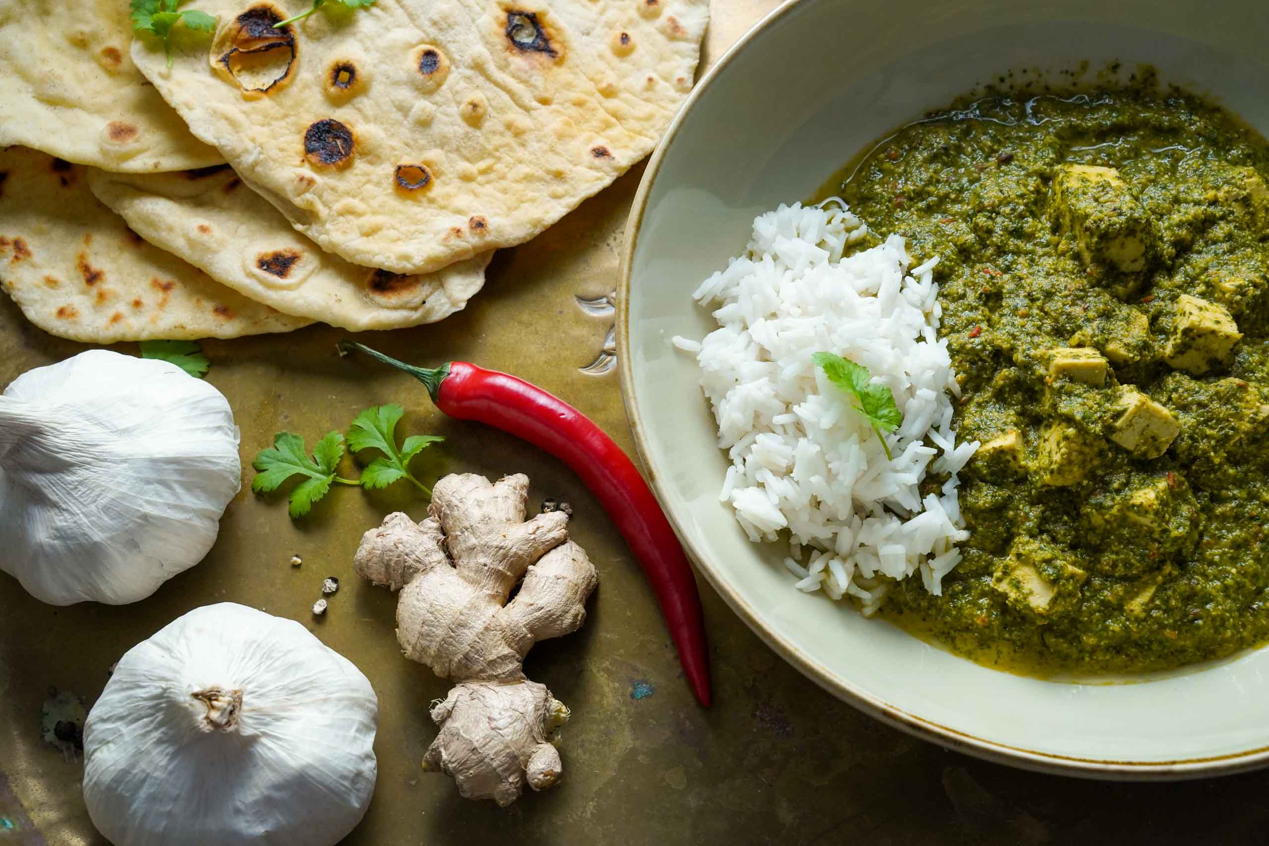 egane Palak Paneer in zwei Schüsseln, dazu Naanbrot. Dekoriert mit frischen Zutaten wie Chili und Knoblauch. Detailansicht. egane Palak Paneer in zwei Schüsseln, dazu Naanbrot. Dekoriert mit frischen Zutaten wie Chili und Knoblauch. Detailansicht.