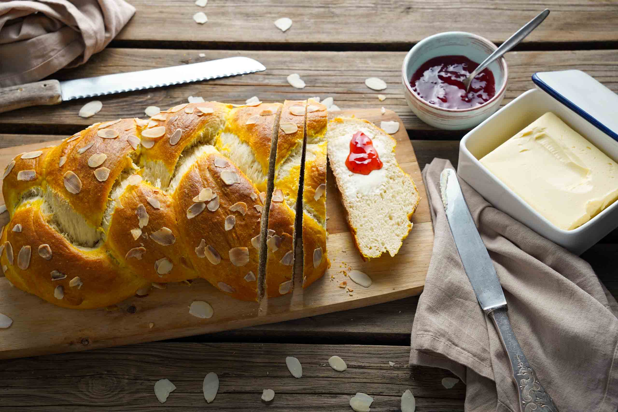 Osterzopf vegan 00 hero 4 zu 3 Osterzopf auf einem Brett, daneben vegane Butter und Marmelade
