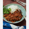 Veganes Tikka Masala im Teller, mit Reis und Koriander angerichtet, Hero