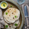 Veganes Naan auf einem Blech, dekoriert mit Koriander, hero slider