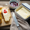 Osterzopf auf einem Brett, daneben vegane Butter und Marmelade  