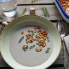 Vegane Champignoncremesuppe in der angewinkelten Draufsicht. Dekoriert mit Thymian und gerösteten Kichererbsen.