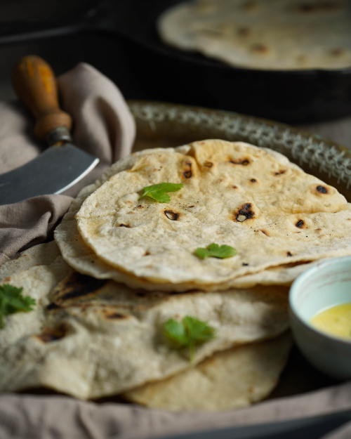 Veganes Naanbrot auf einem Blech, dekoriert mit Koriander, teaser  